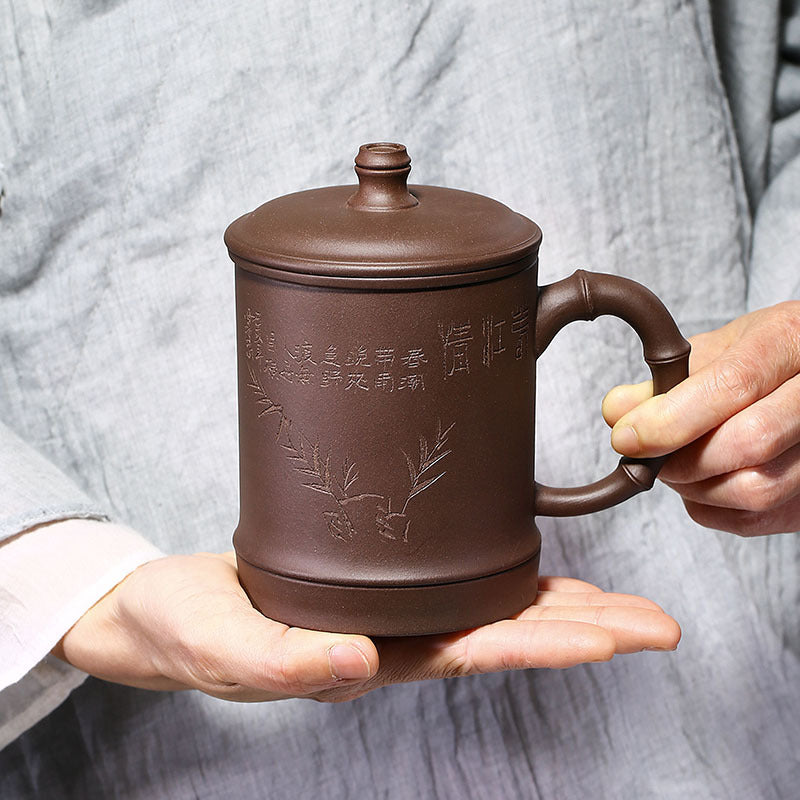 Handmade Yixing purple sand cup with elegant engravings, perfect for office gifts and tea enthusiasts.