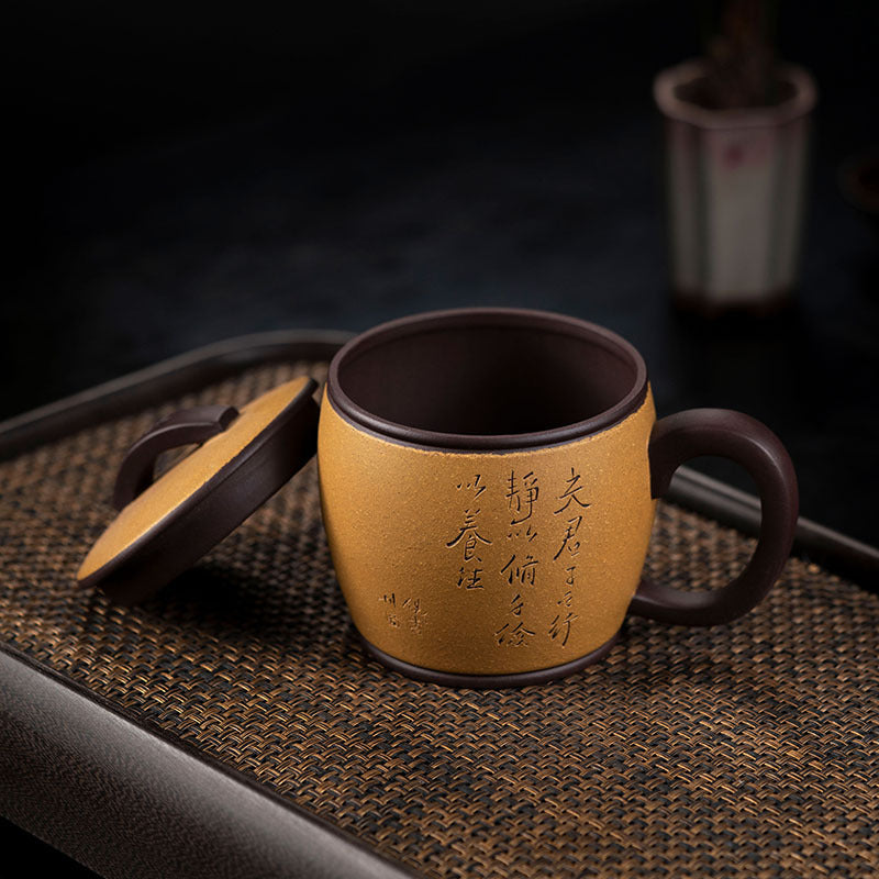 Handmade Yixing purple sand teacup with a lid, featuring elegant calligraphy, perfect for tea enthusiasts.