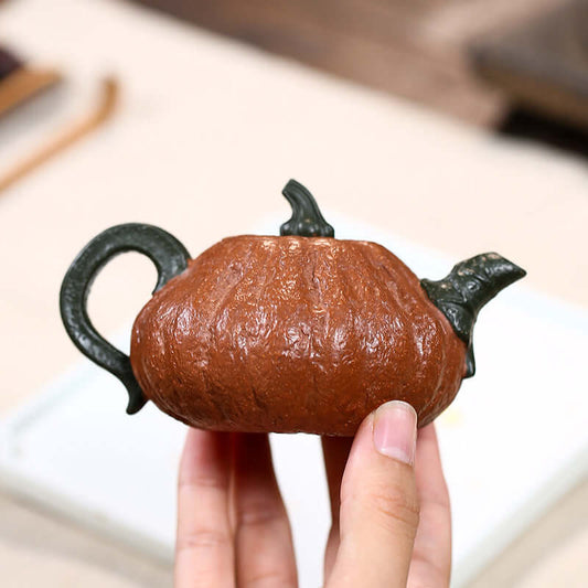 Handmade Yixing purple sand teapot shaped like a pumpkin, showcasing intricate details and craftsmanship.