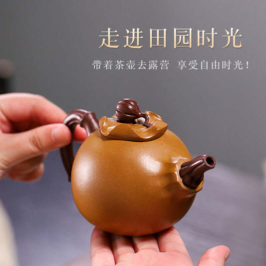 Handmade Yixing purple sand teapot, shaped like a golden gourd, held in a hand, showcasing its unique design.