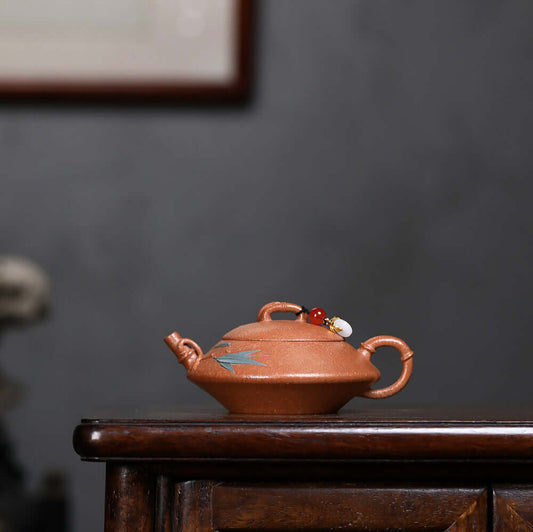 Handmade Yixing purple sand teapot with intricate design, perfect for Kung Fu tea ceremonies, displayed on a wooden table.