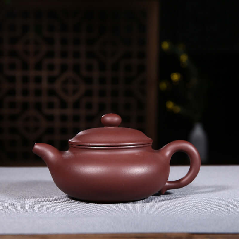 Handmade Yixing purple sand teapot, showcasing elegant design and craftsmanship, perfect for tea lovers.