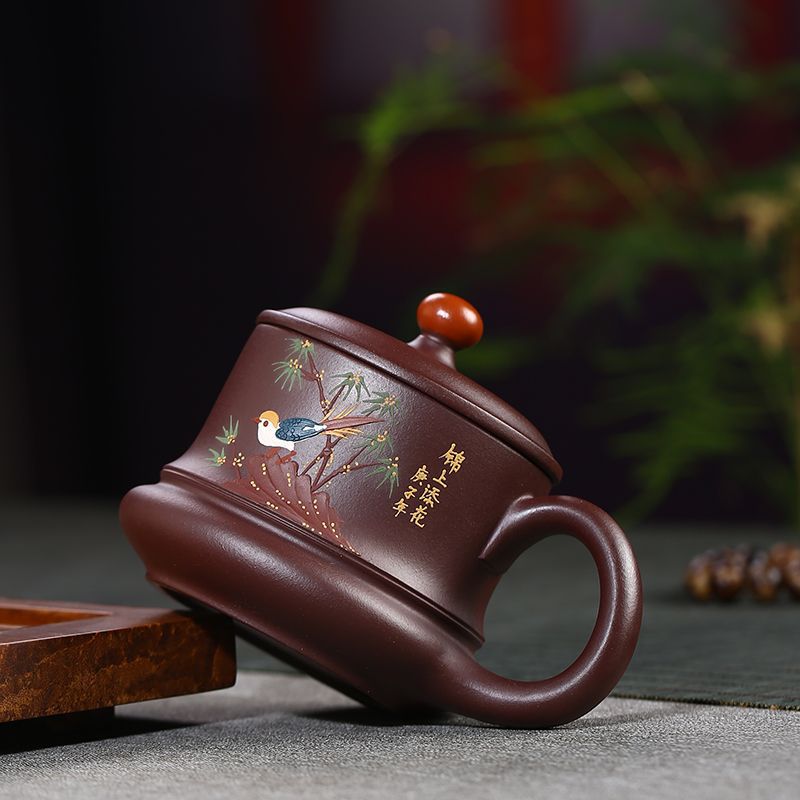 Handmade Yixing purple sand tea cup with floral and bird painting, featuring a curved handle and unique lid design.