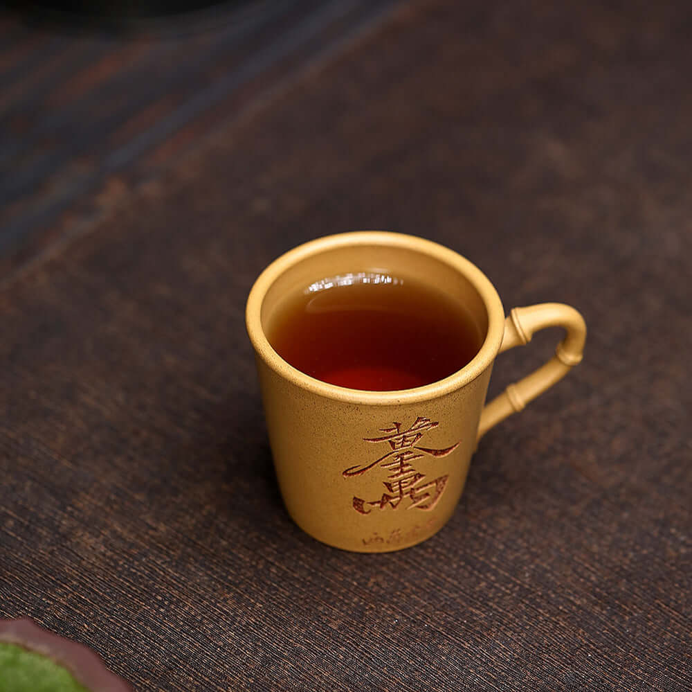 Handmade Yixing purple sand tea cup with bamboo carving, ideal for home kung fu tea set, showcasing original craftsmanship.
