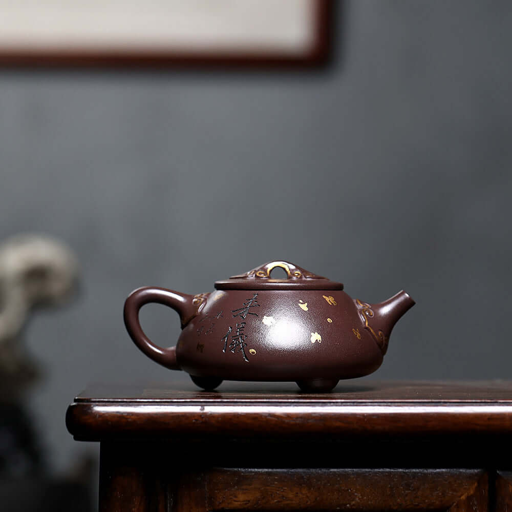 Handmade Yixing purple sand teapot with gold detailing, perfect for household tea sets and crafted by skilled artisans.