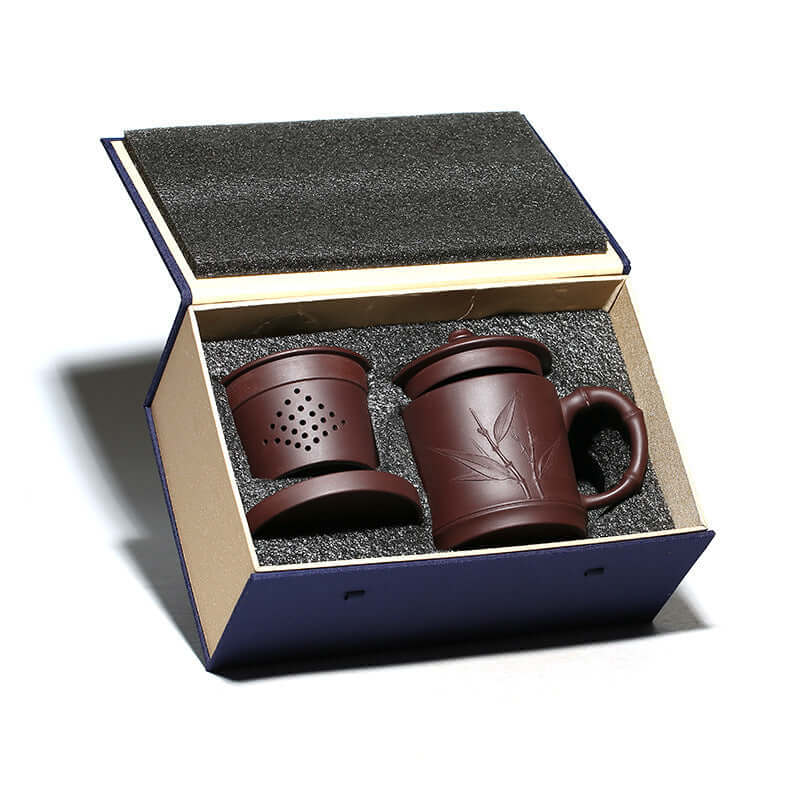 Handmade Yixing purple sand tea set featuring a cup and strainer, elegantly packaged as a three-piece gift.