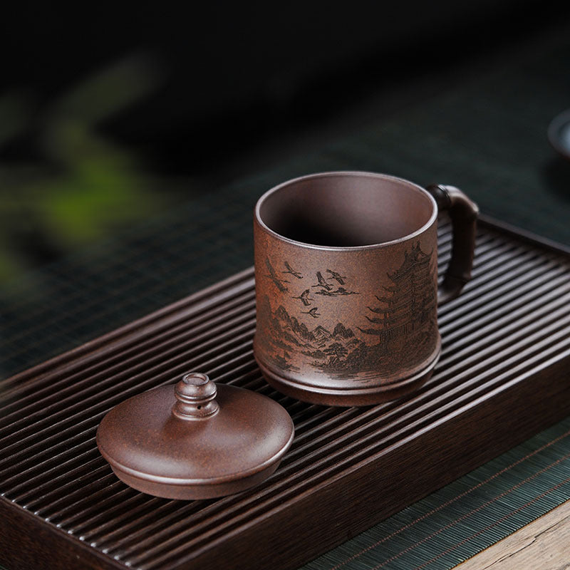 Handmade Yixing purple sand teacup with intricate mountain design, perfect for tea lovers and collectors.