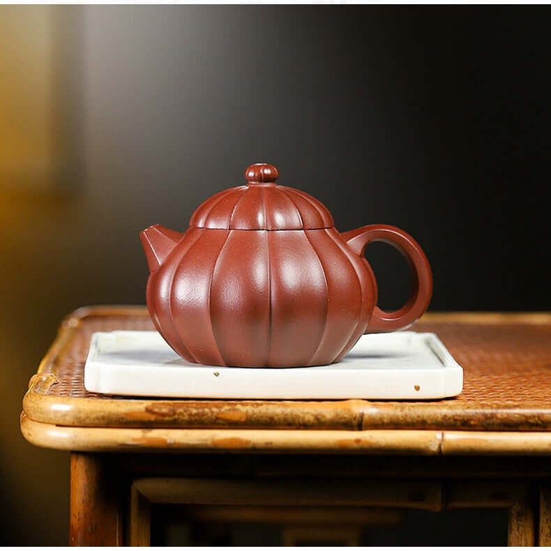 Handmade Yixing purple sand teapot with a unique pumpkin design, crafted by skilled Yixing artisans.