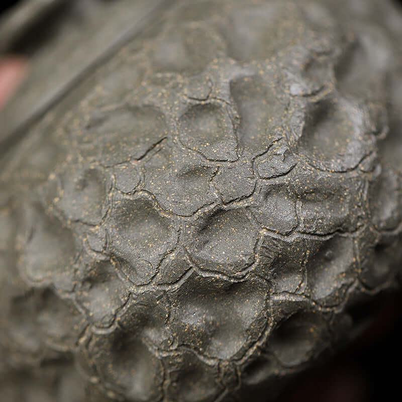 Close-up of handmade Yixing purple sand teapot showing original raw ore texture and intricate craftsmanship.