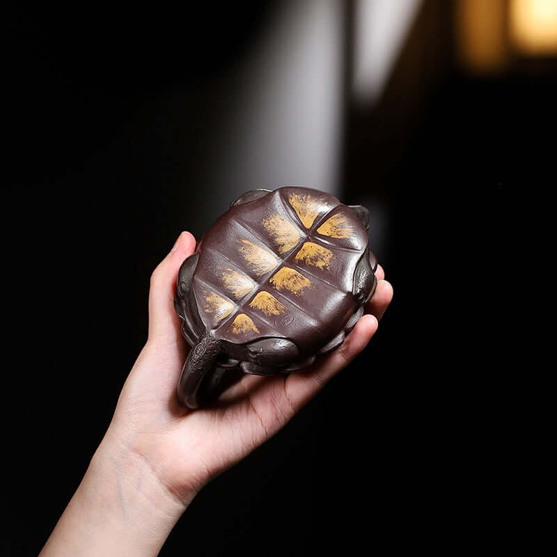Handmade Yixing purple sand teapot shaped like a tortoise, crafted from original purple sand for household tea brewing.
