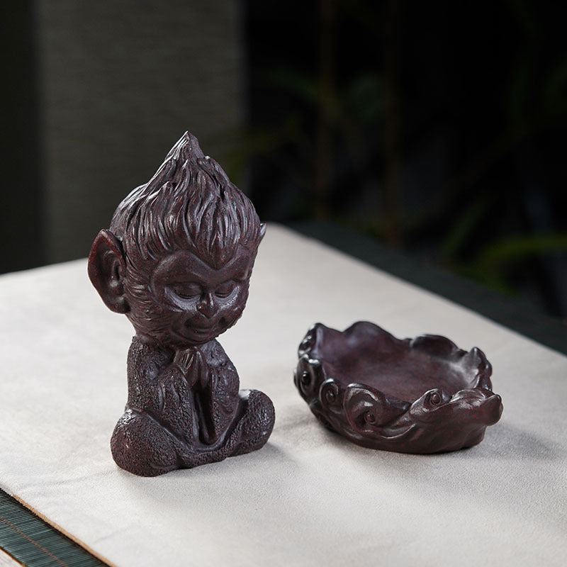 Handmade Yixing purple sand Sun Wukong ornament and tea pet on a tea table, showcasing unique craftsmanship.