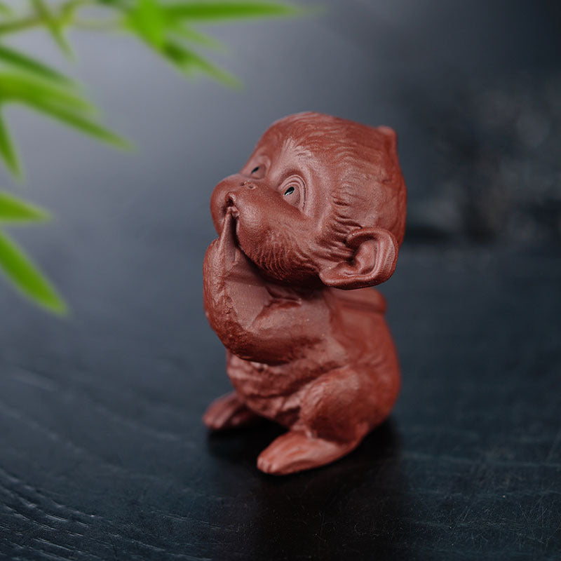 Handmade Yixing purple sand tea pet monkey sculpture, perfect for tea table decor and collectors.
