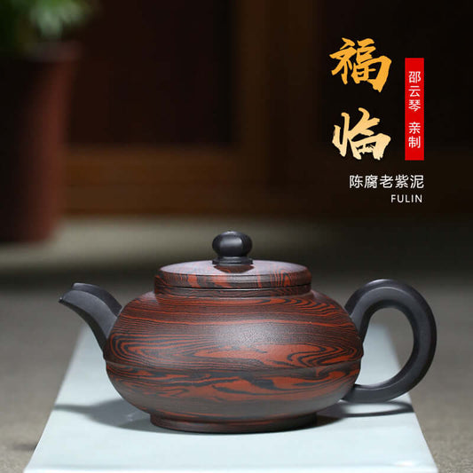 Handmade Yixing purple sand teapot in a traditional design, showcasing rich colors and fine craftsmanship.