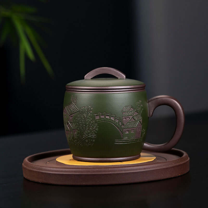 Handmade Yixing purple sand tea cup with green mud, featuring traditional Jiangnan scenery, perfect for tea lovers.