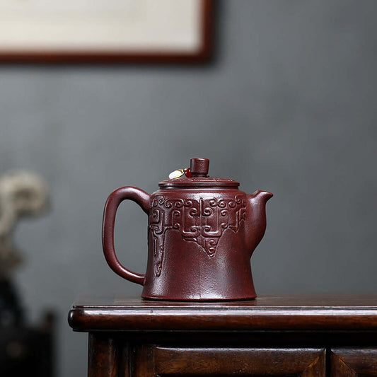 Handmade Yixing purple sand teapot with intricate design, crafted from ancient red mud for a traditional tea experience.