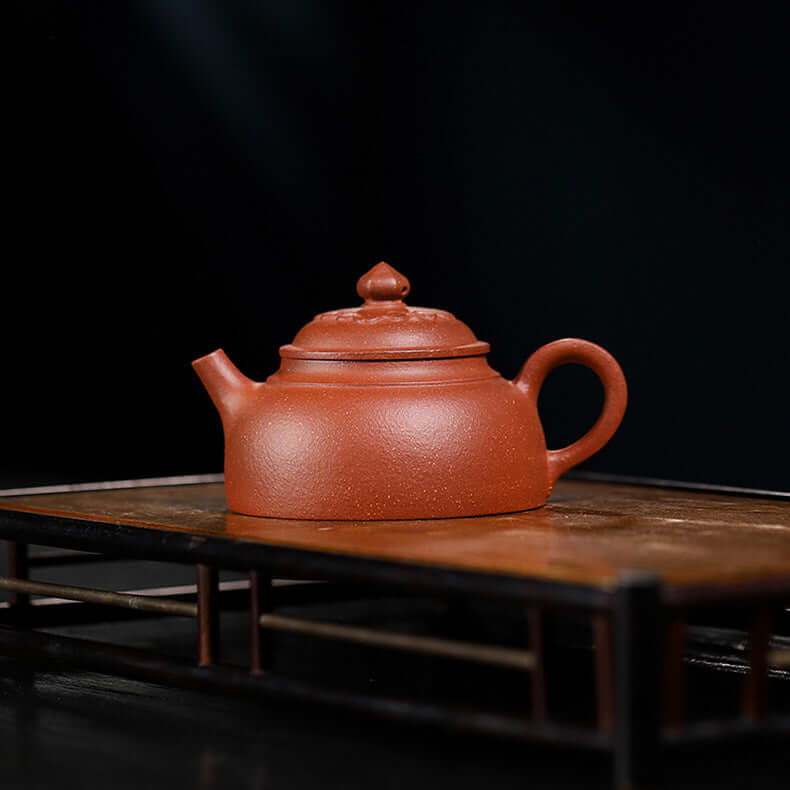 Handmade Yixing purple sand teapot on a wooden tray, showcasing the original purple clay craftsmanship.