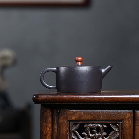 Handmade Yixing purple sand teapot on a wooden table, perfect for Kung Fu tea ceremonies.