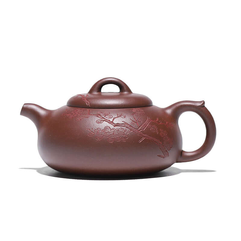 Handmade Yixing purple sand teapot with engraved floral design, showcasing traditional Chinese craftsmanship.