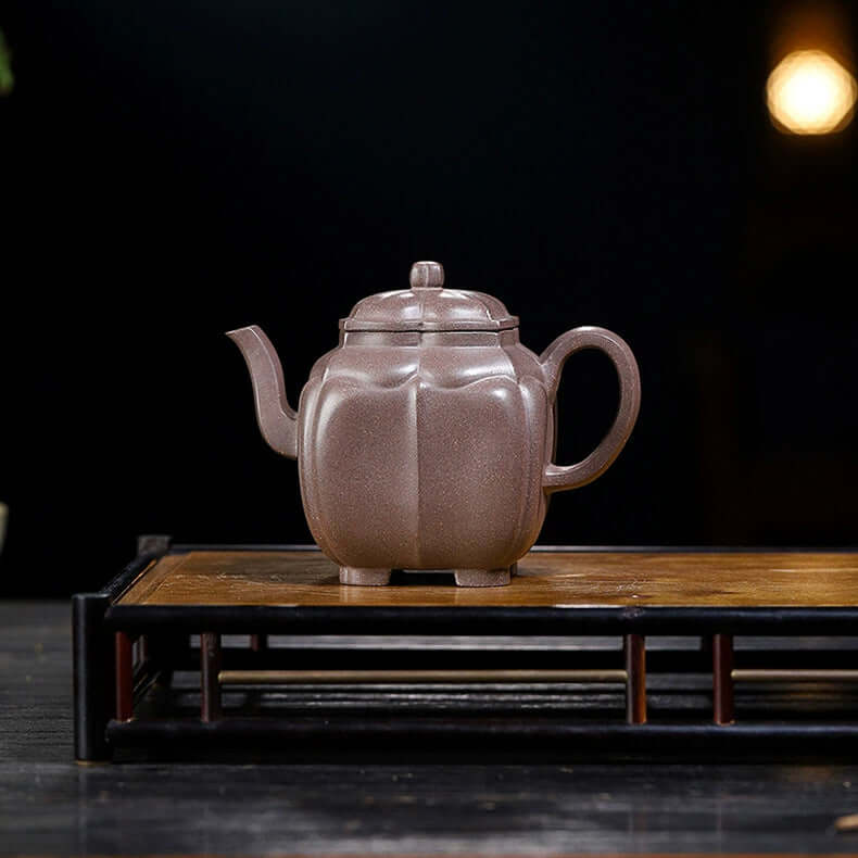 Handmade Yixing purple sand teapot with unique design on wooden tea tray, showcasing artisanal craftsmanship and original materials.