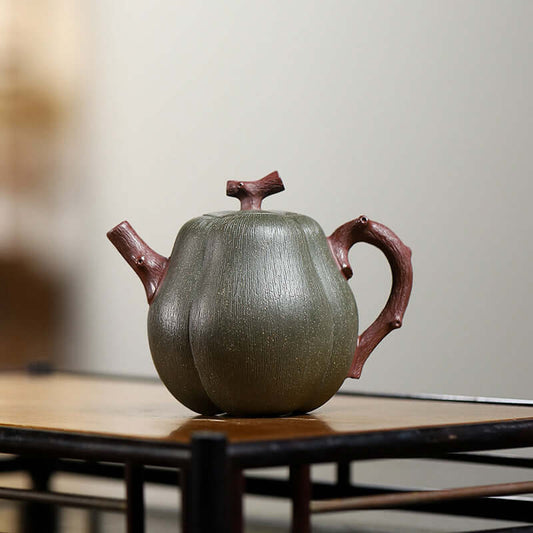 Handmade Yixing purple sand teapot in pear melon shape, showcasing green clay with elegant design and craftsmanship.