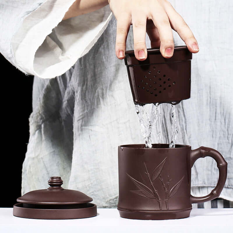 Handmade Yixing purple sand cup with bamboo design, tea brewing process showing infuser and water being poured.