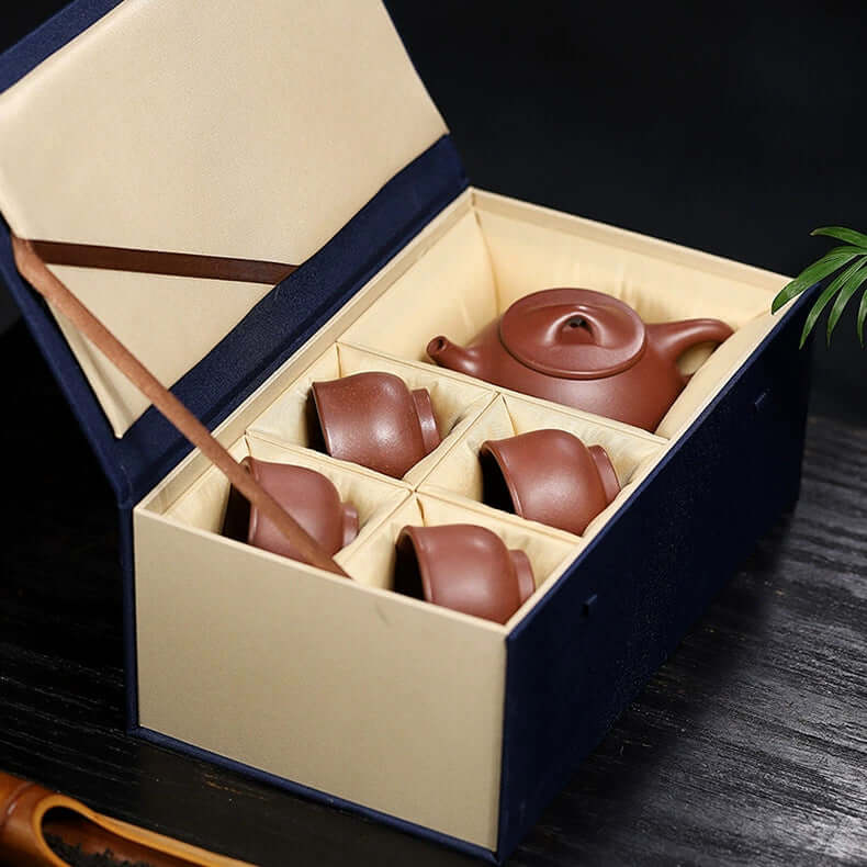 Handmade Yixing purple sand teapot set in elegant box with cups, showcasing original craftsmanship and unique design.