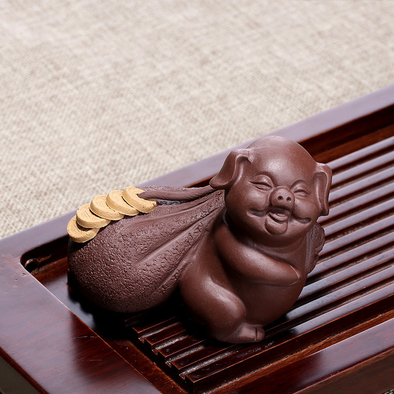Handmade Yixing purple sand pig figurine with a money bag, perfect for tea tray decoration and good fortune.