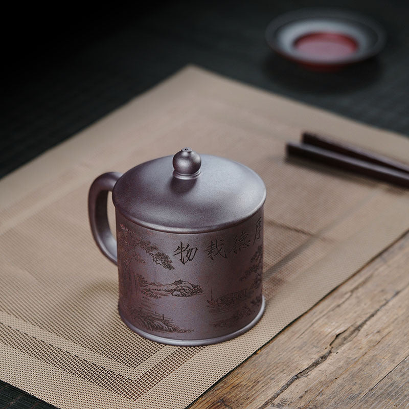 Handmade Yixing purple sand cup with landscape design, perfect for tea enthusiasts, showcasing artisan craftsmanship.