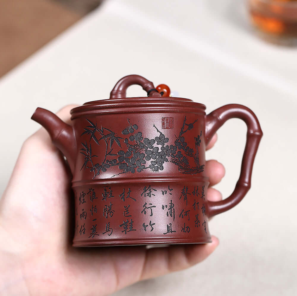 Handmade Yixing purple sand teapot featuring intricate bamboo and floral design, perfect for Kung Fu tea set.