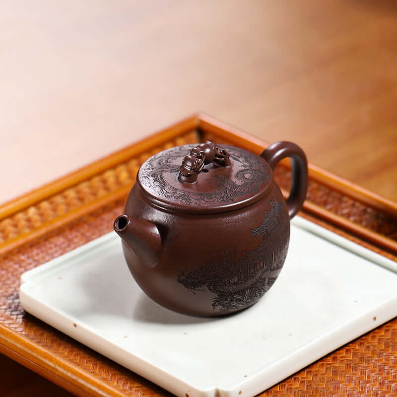 Handmade Yixing purple sand teapot with dragon design, showcasing craftsmanship and elegant curves.