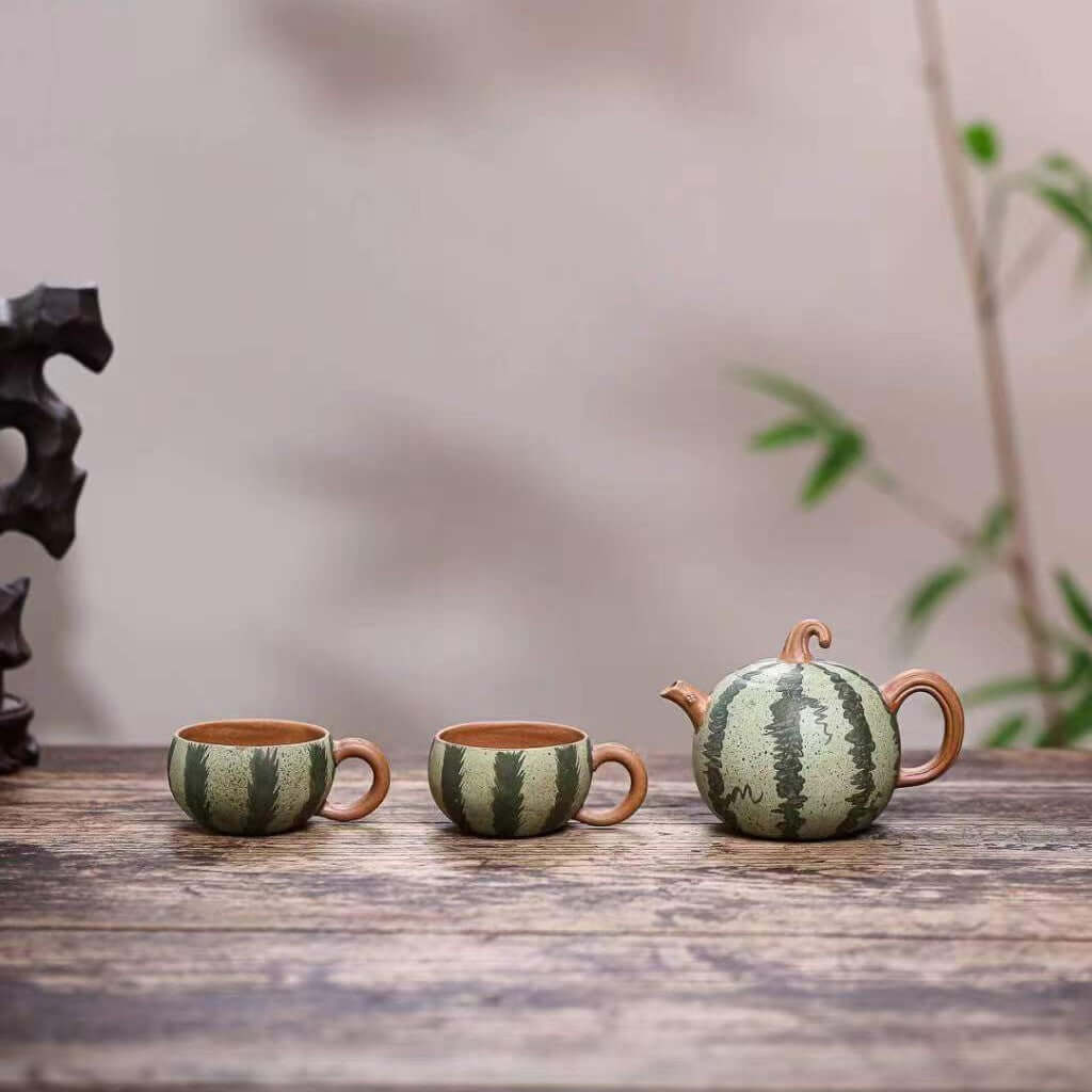 Handmade Yixing purple sand teapot and cups in watermelon design, perfect for tea enthusiasts and collectors.