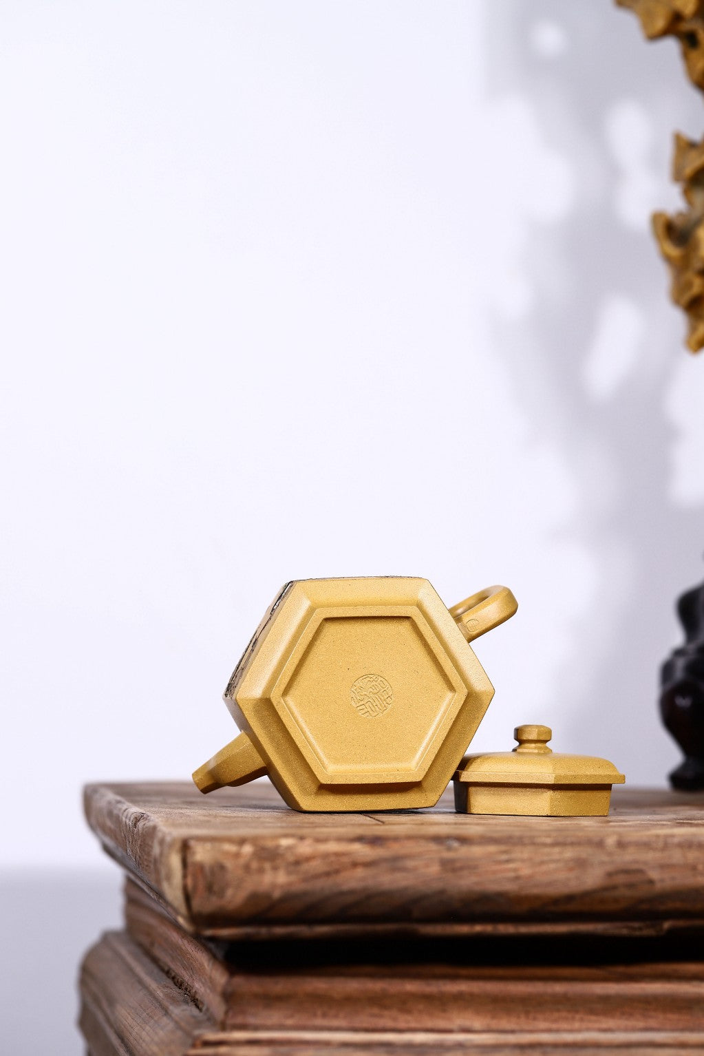 Handmade Yixing purple sand teapot in hexagonal design, showcasing intricate craftsmanship and golden finish.