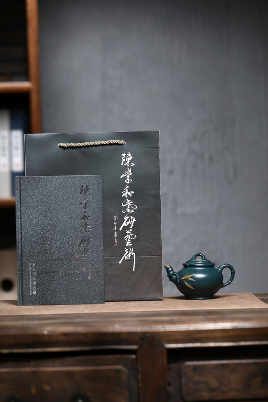 Handmade Yixing purple sand teapot with gift box and certificate on wooden table.