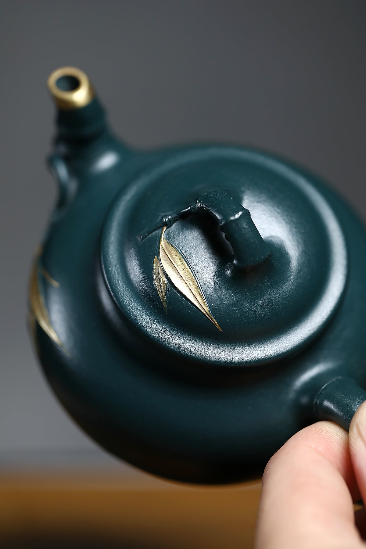 Handmade Yixing purple sand teapot with bamboo leaf design, showcasing exquisite craftsmanship and unique green clay.