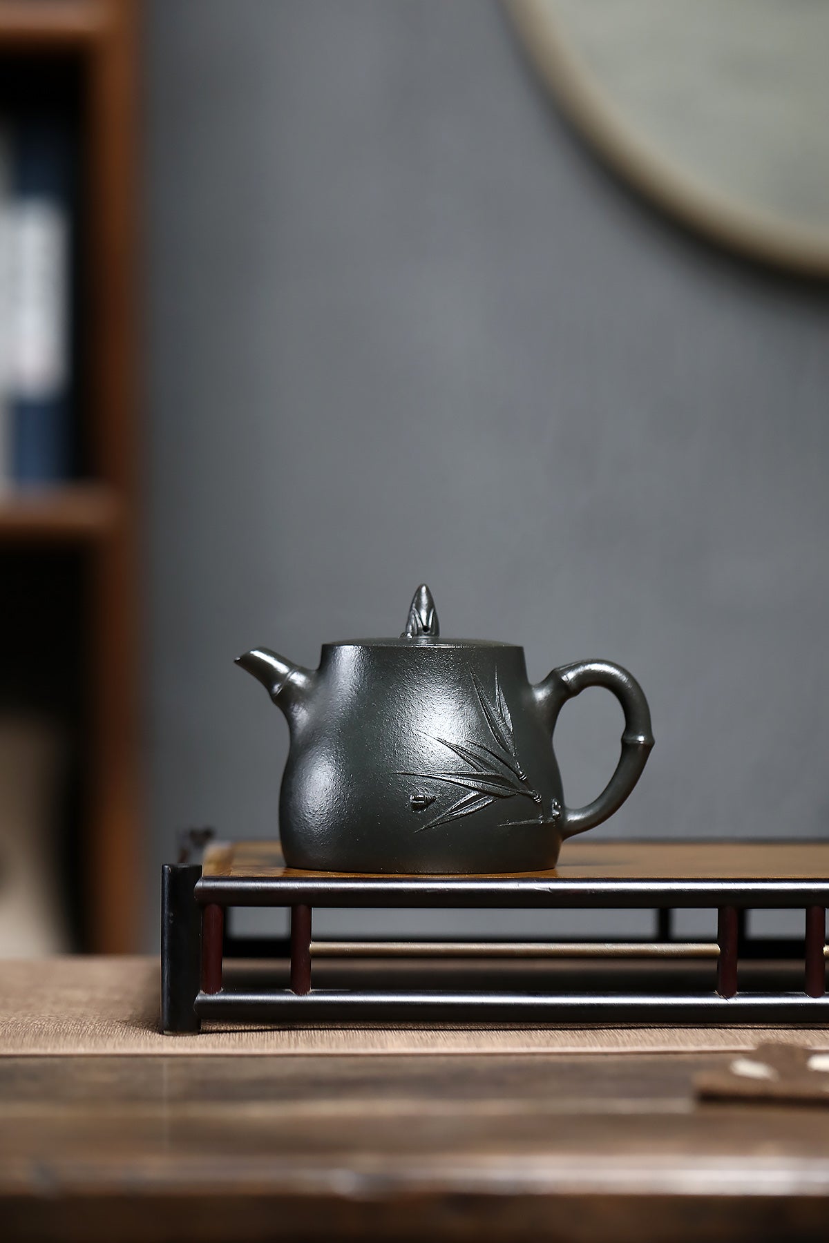 Handmade Yixing purple sand teapot featuring bamboo design on a wooden tea tray.