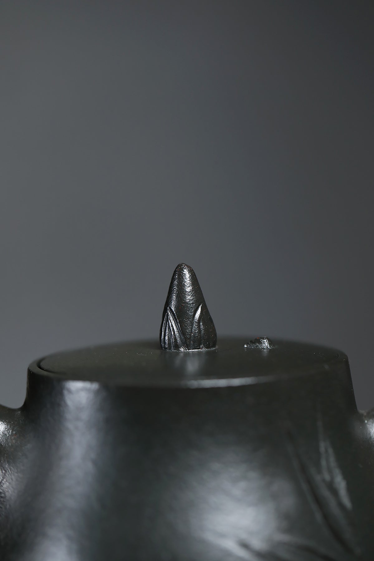 Close-up of the lid detail of a handmade Yixing purple sand teapot featuring a bamboo-inspired knob.
