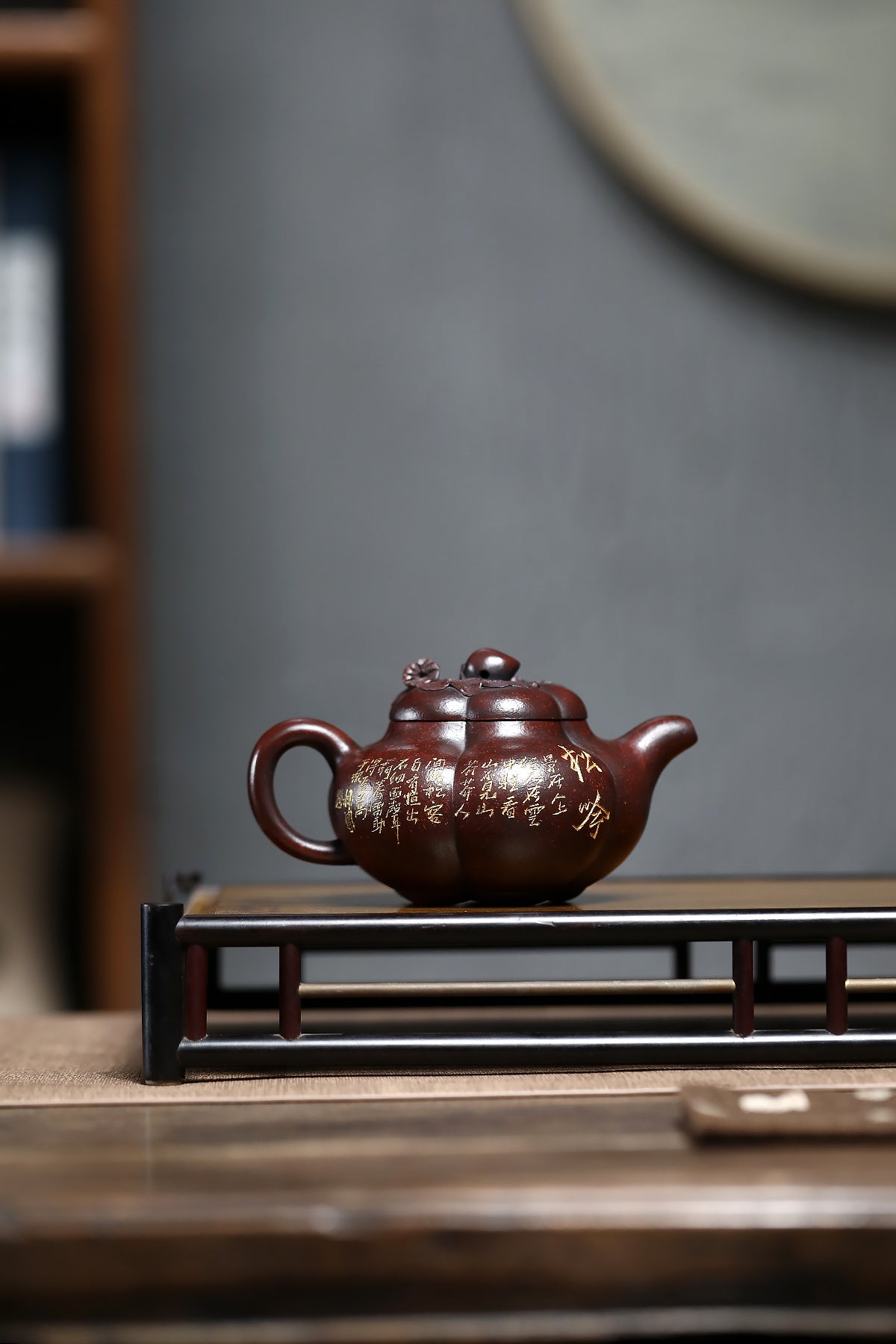 Handmade Yixing purple sand teapot featuring a traditional peach design, displayed elegantly on a wooden stand.