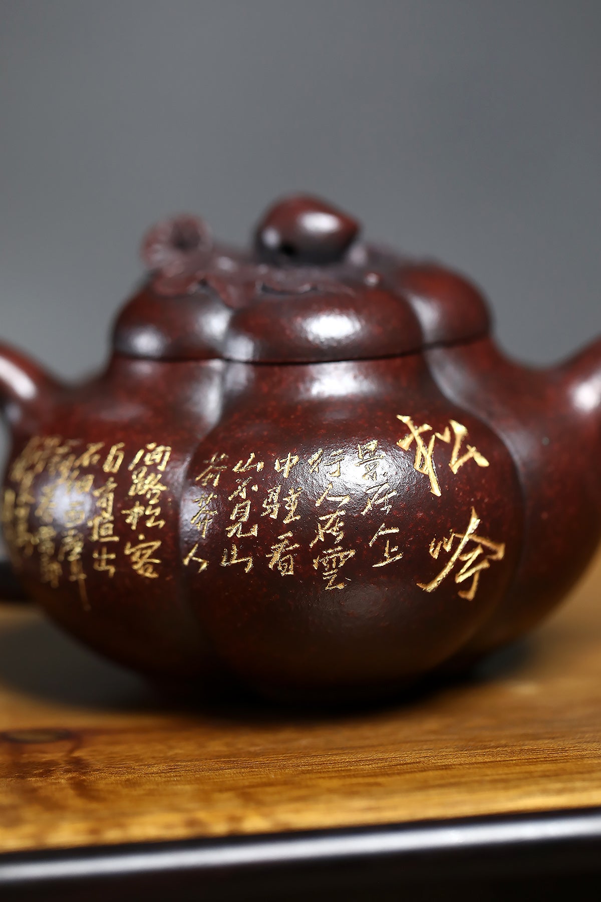 Handmade Yixing purple sand teapot with intricate golden inscriptions, showcasing traditional craftsmanship and artistry.