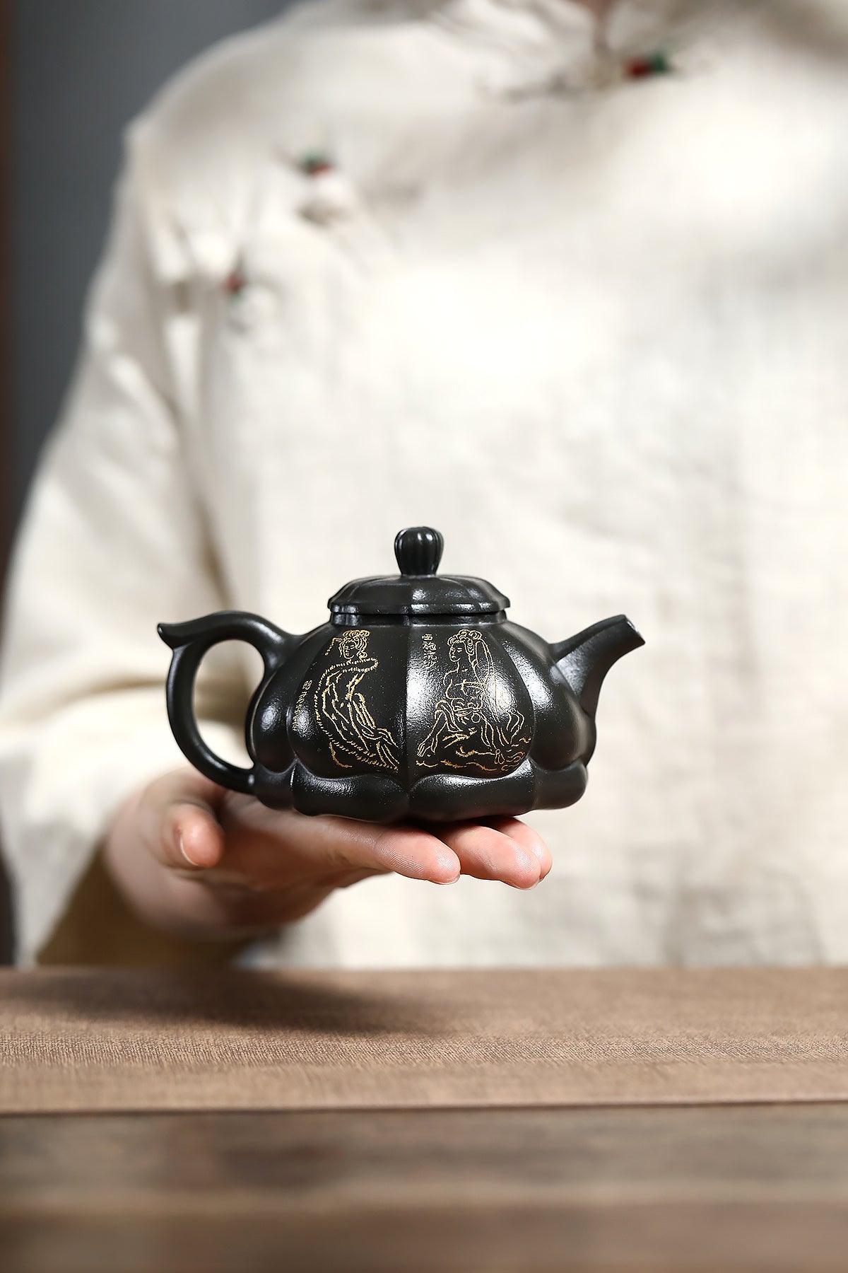 Handmade Yixing purple sand teapot featuring gold accents, crafted by master artisan Chen Xuehe.