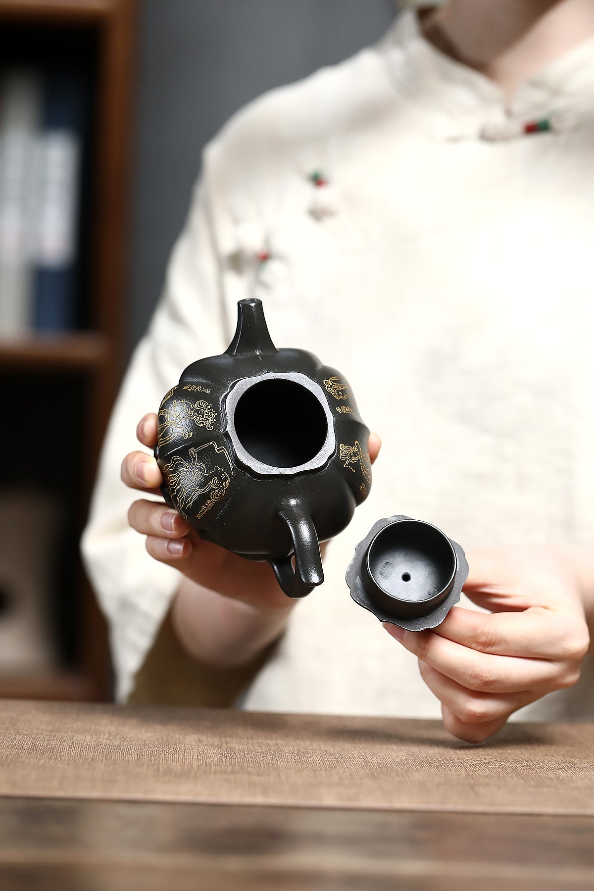 Handmade Yixing purple sand teapot with intricate detailing, held by a person, showcasing unique craftsmanship.