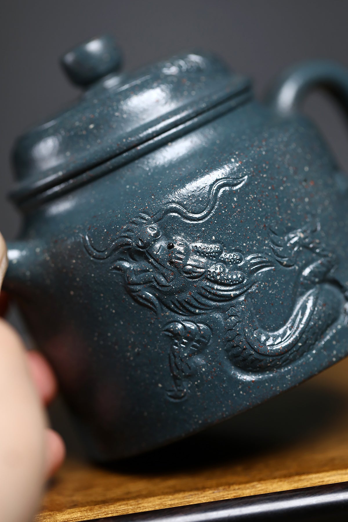 Handmade Yixing purple sand teapot featuring intricate dragon design and snowflake green clay, showcasing traditional craftsmanship.