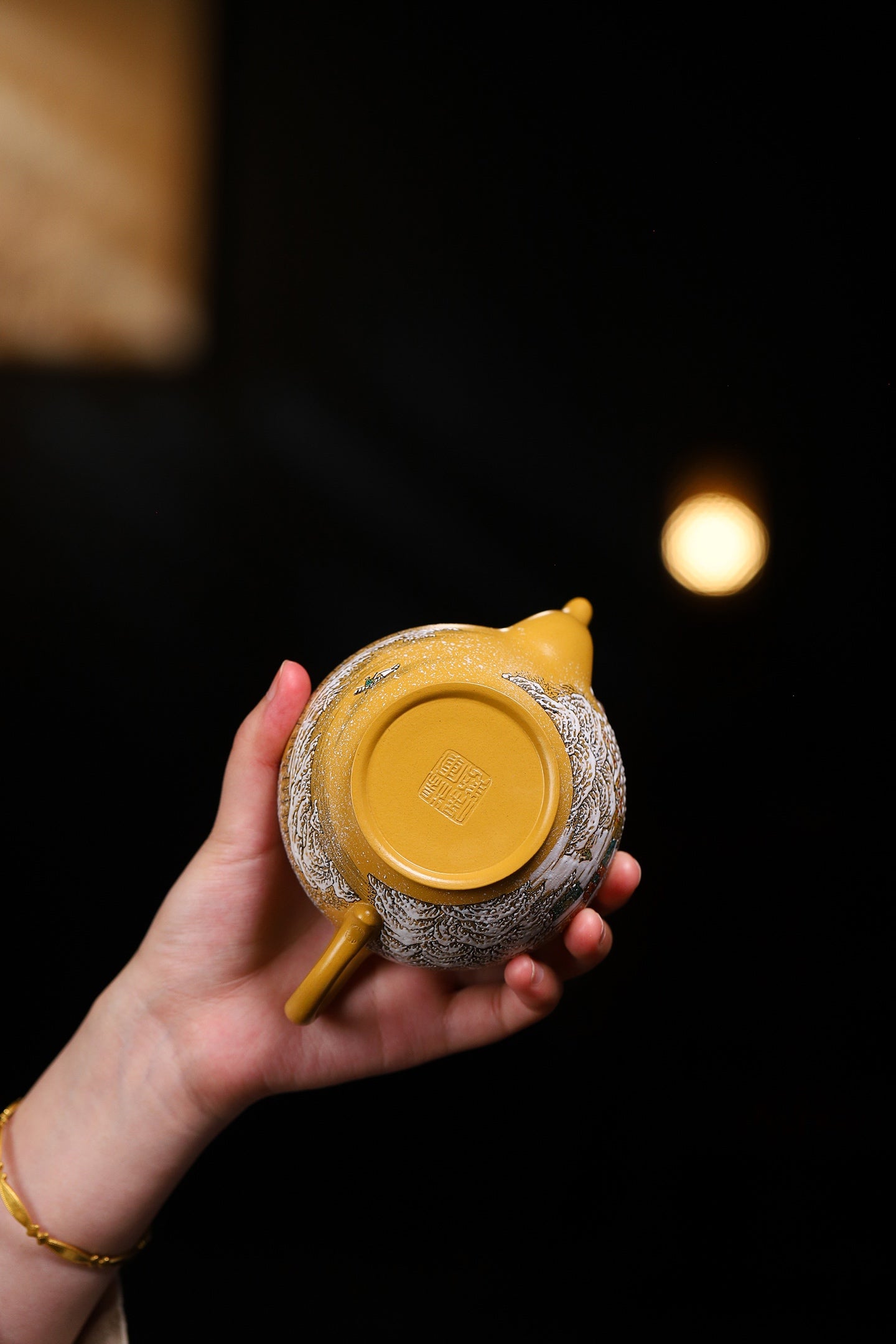 Handmade Yixing purple sand teapot with intricate design, shown from below, highlighting craftsmanship and unique aesthetics.