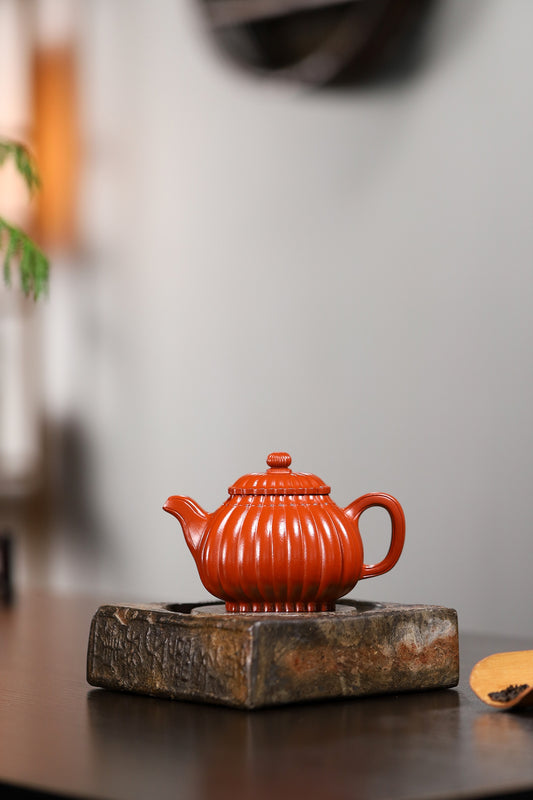 Handmade Yixing purple sand teapot on a wooden stand, showcasing traditional craftsmanship and intricate design.