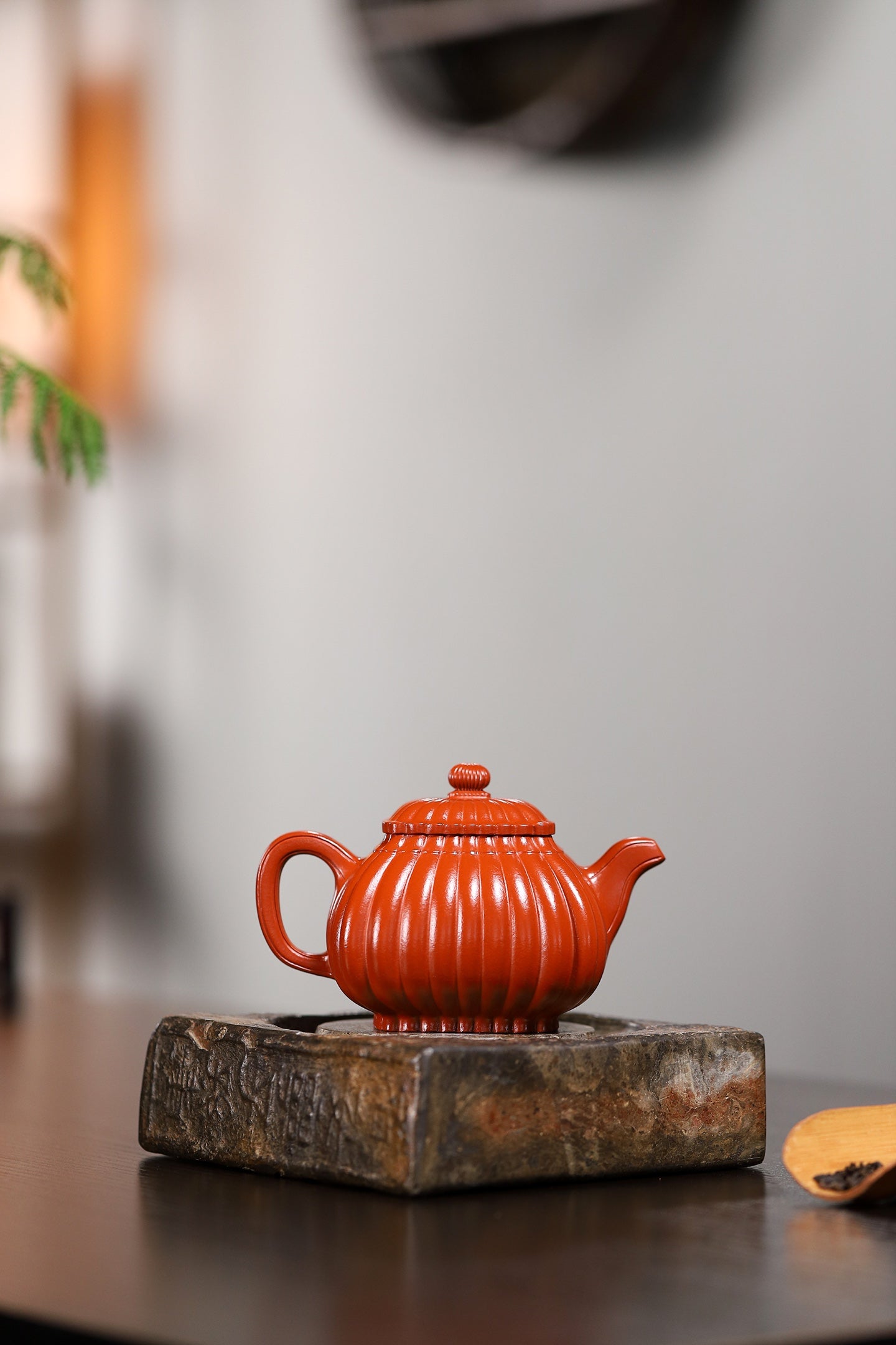 Handmade Yixing purple sand teapot, featuring a ribbed design and a round knob on top, displayed on a wooden stand.