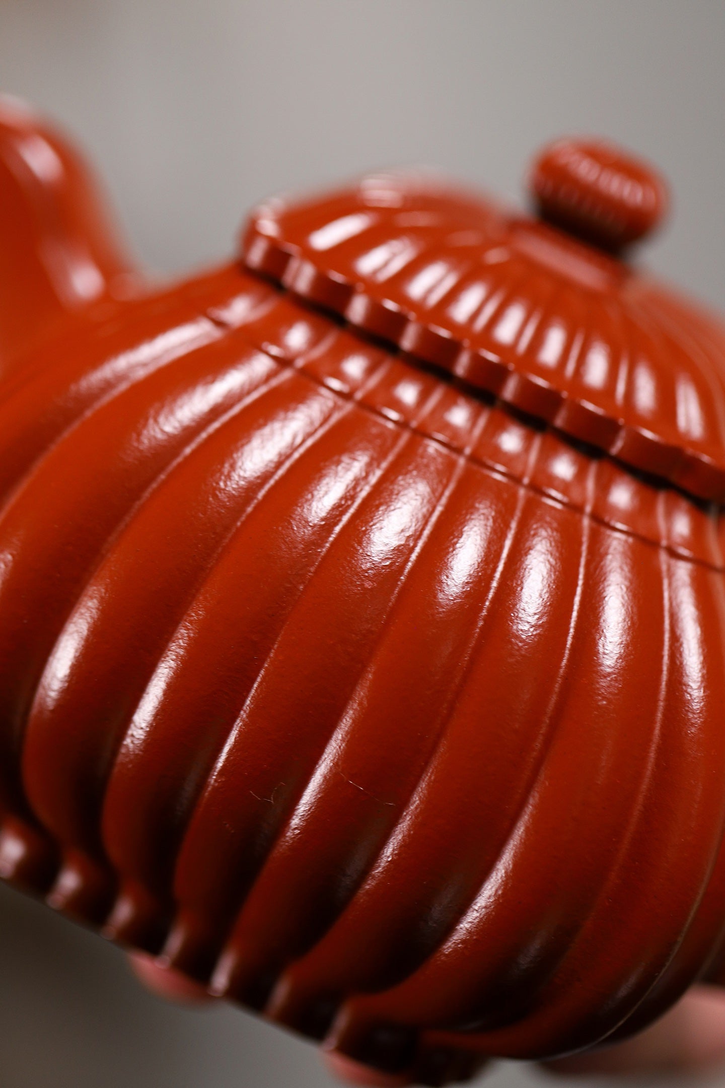 Handmade Yixing purple sand teapot with a ribbed design and glossy finish, showcasing traditional craftsmanship.