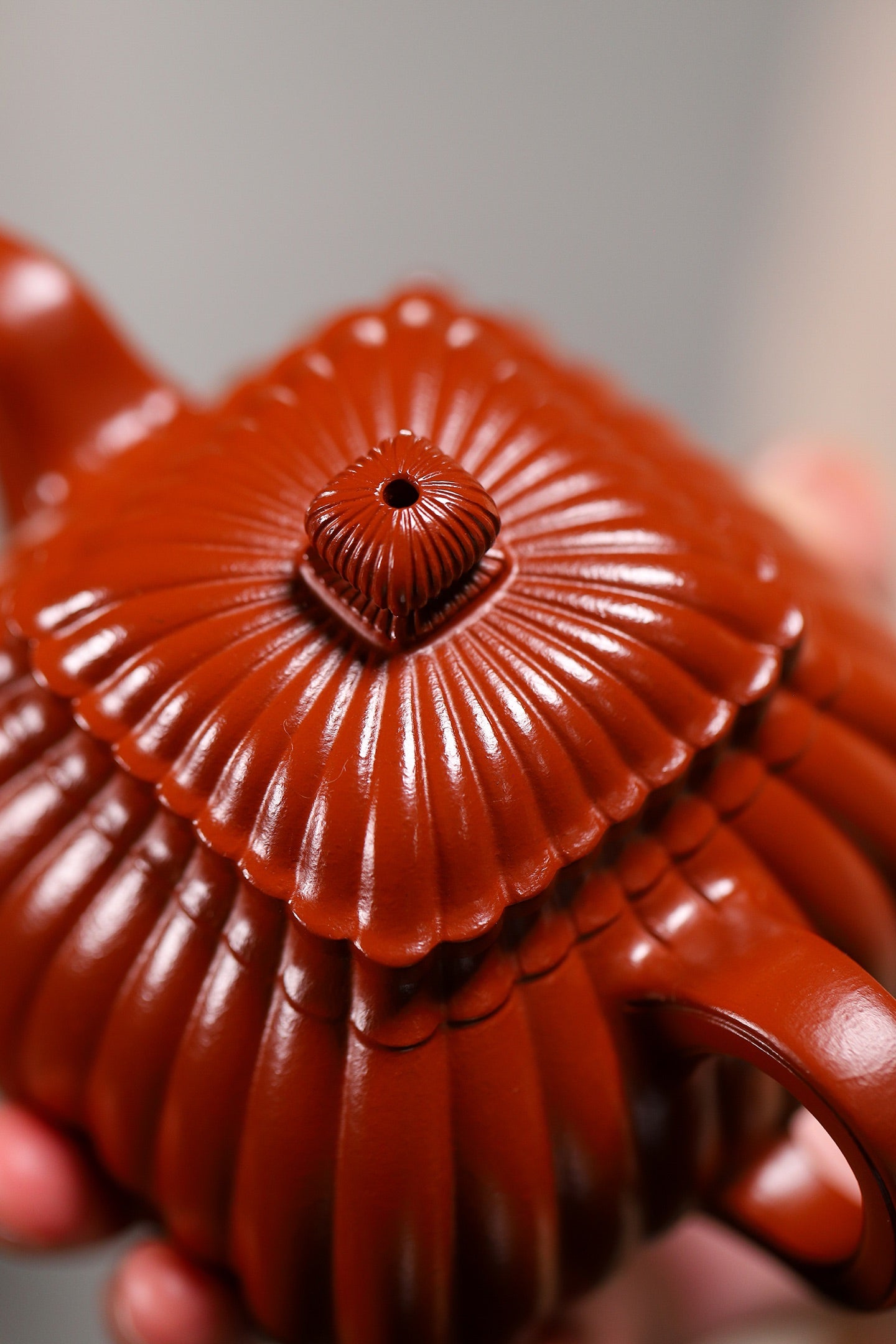 Handmade Yixing purple sand teapot with intricate ribbed design and elegant round lid, showcasing unique crafting details.