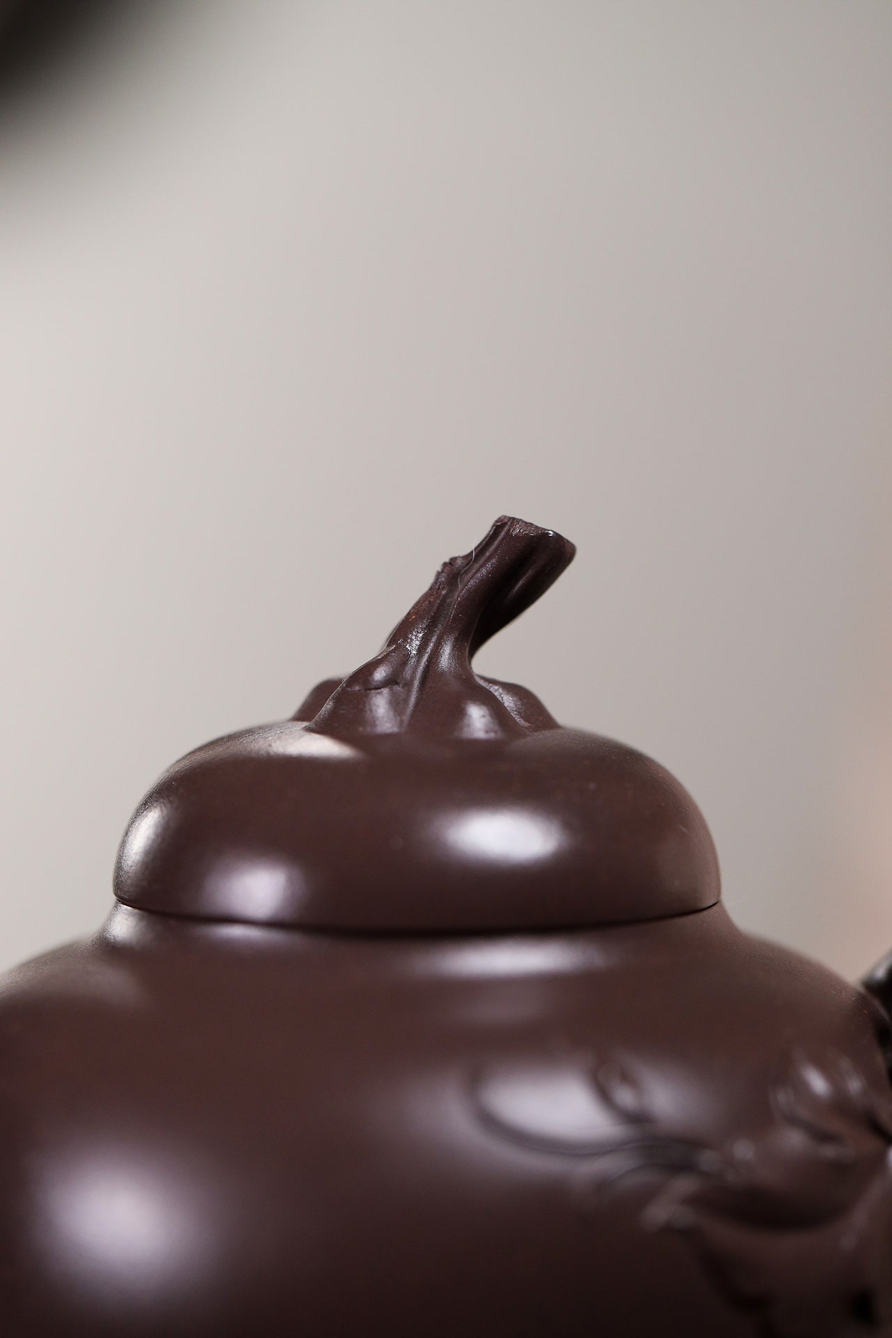 Close-up of a handmade Yixing purple sand teapot featuring unique lid design and craftsmanship.