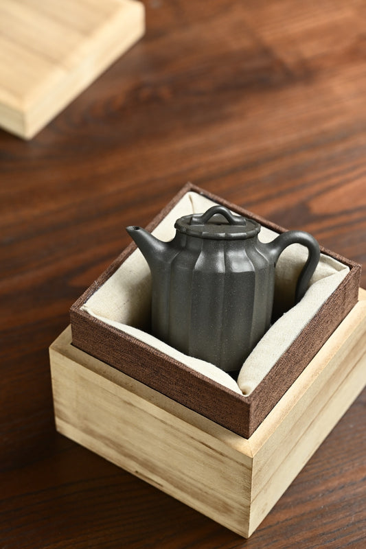 Handmade Yixing purple sand teapot in decorative box, showcasing unique craftsmanship and elegant design.