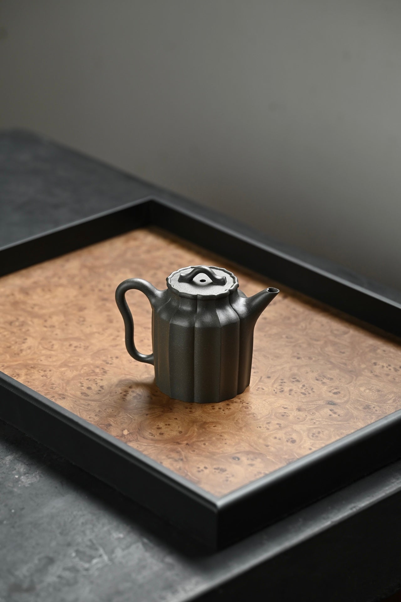 Handmade Yixing purple sand teapot on a wooden tray, showcasing unique design and craftsmanship.
