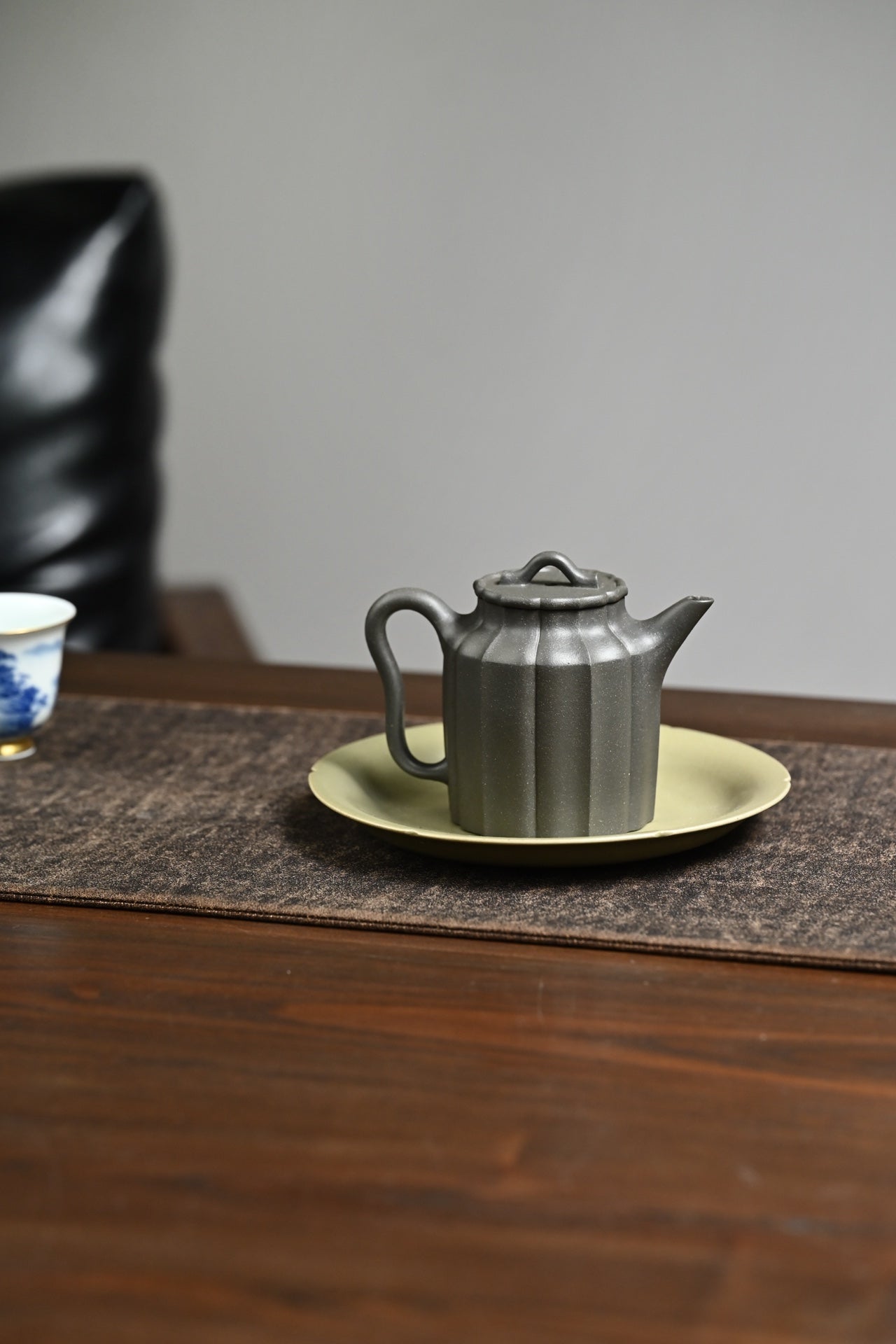 Handmade Yixing purple sand teapot on a yellow plate, showcasing exquisite craftsmanship and elegant design.